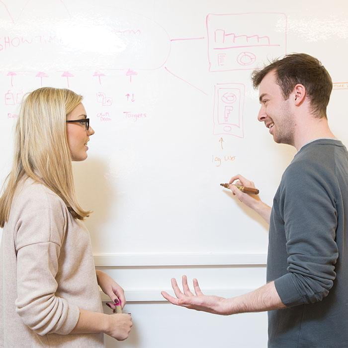 Man drawing on office whiteboard surface created with smart whiteboard wallpaper during meeting - Conference Room Whiteboards